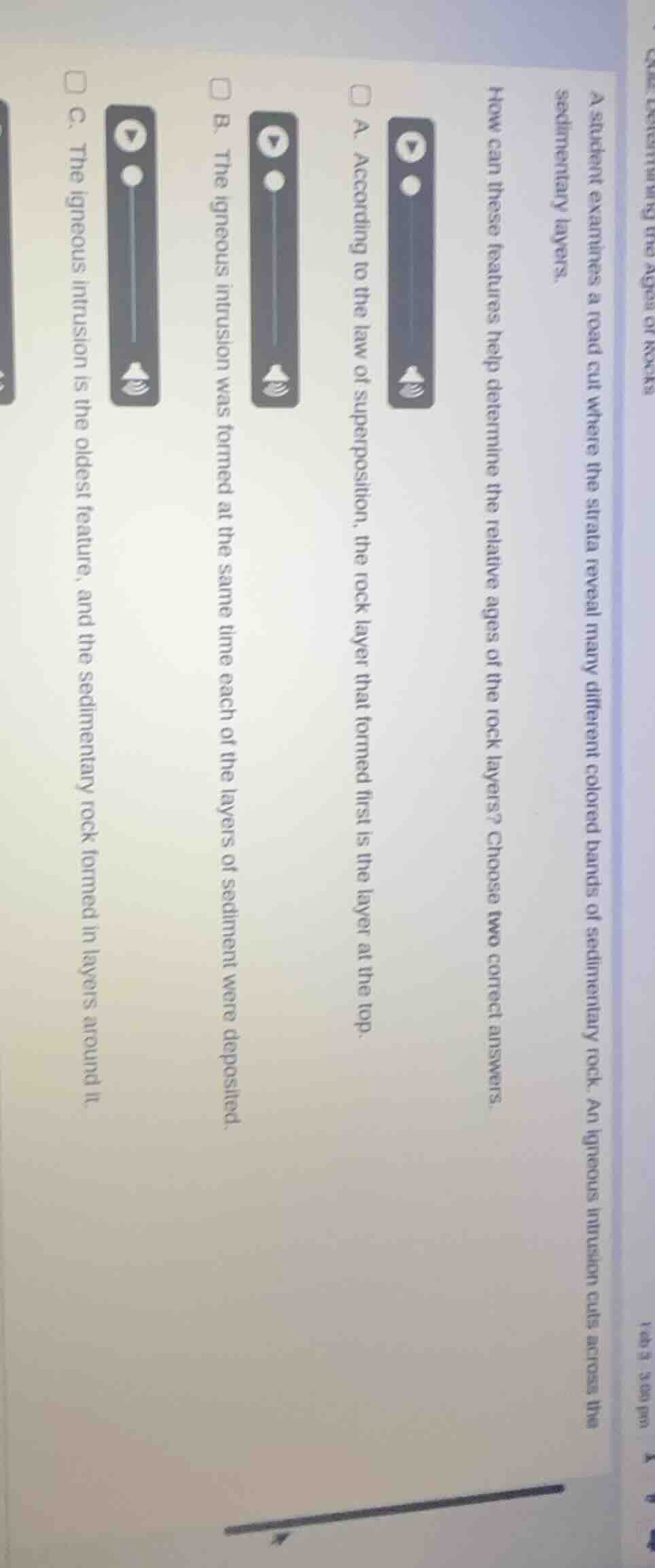 a student examines a road cut where the strata reveal many different co…