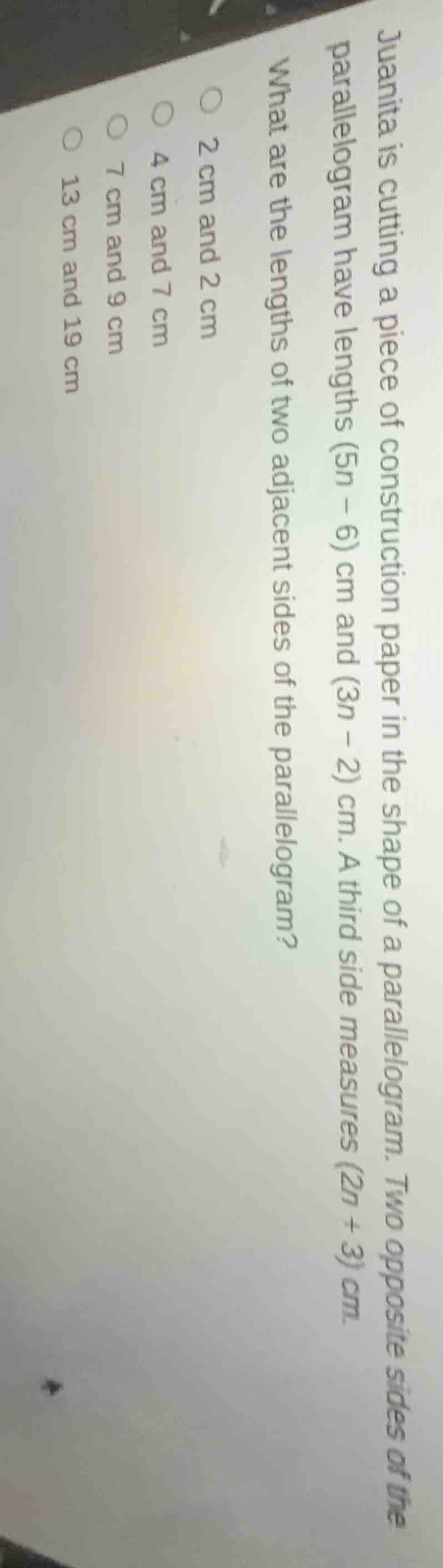 juanita is cutting a piece of construction paper in the shape of a para…